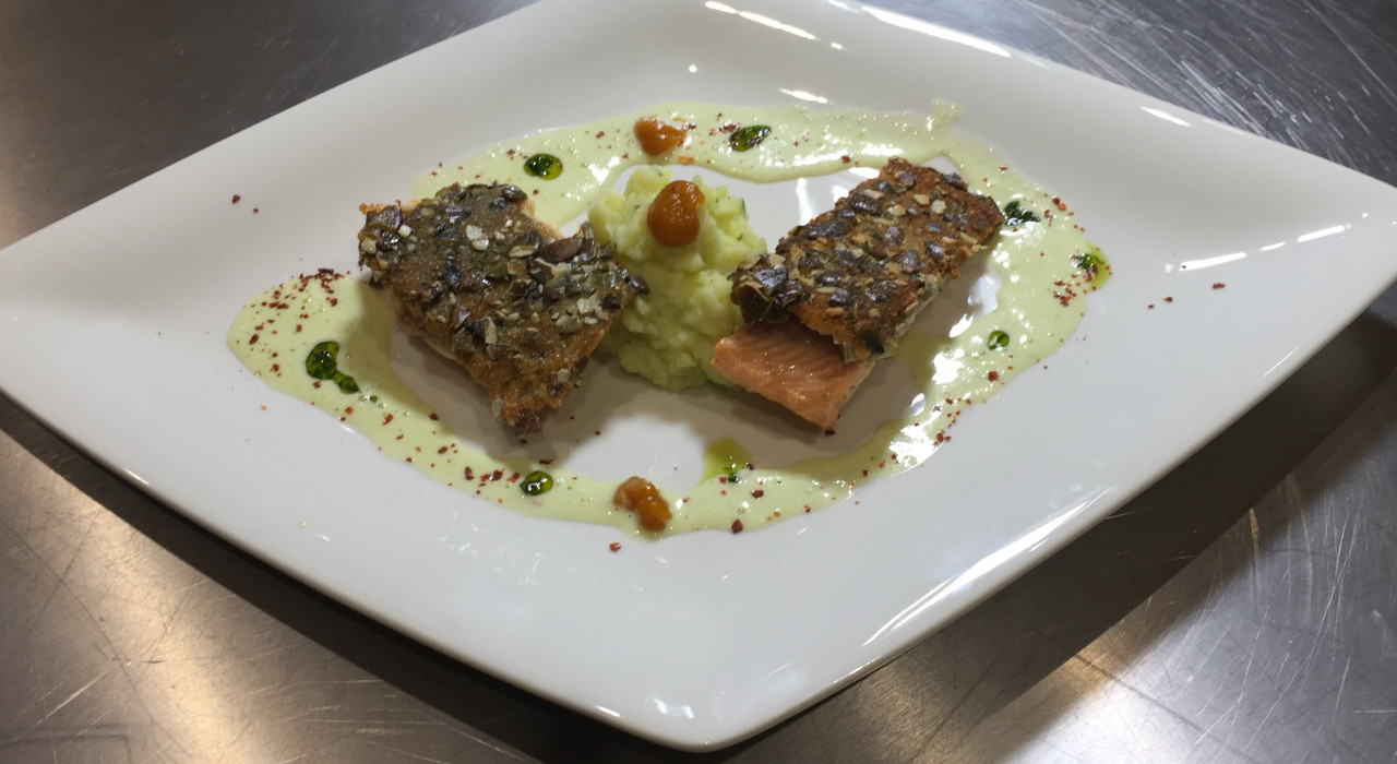 Lachsforellenforellenfilet in der Kürbiskernkruste mit Erdäpfel Bärlauch Püree auf Frühlingszwiebelschaum